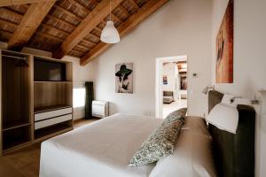 a bedroom with a white bed and a television at Villa Bido in Anguillara Veneta