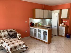 a kitchen with orange walls and a white refrigerator at Soft Horizon Apartment in Loutraki