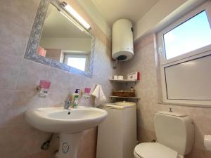 a bathroom with a sink and a toilet and a mirror at Soft Horizon Apartment in Loutraki +21 photos