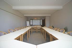 an empty room with long tables and chairs at Hotel des Ardennes in Corbion