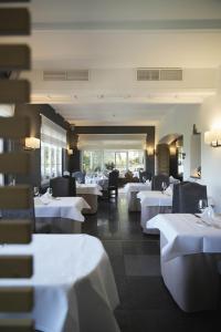 a dining room with white tables and chairs at Hotel des Ardennes in Corbion