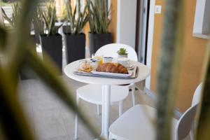 a white table with a plate of food on it at B&B MargAni Tropea in Tropea