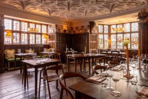 a dining room with tables and chairs and windows at Castle Lodge in Ludlow