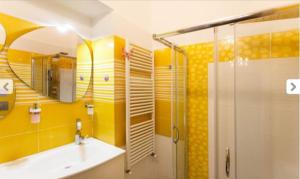 a yellow bathroom with a shower and a sink at Casa Dani&Swing Bed&Books in Turin