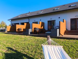 a house with a hammock in front of it at Apartamenty LilaRóż in Brzozie Polskie
