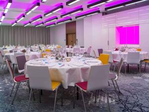 a conference room with white tables and chairs and purple lighting at Mercure Krakow Stare Miasto in Krakow