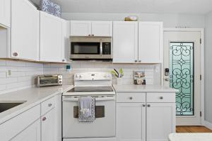 a kitchen with white cabinets and a stove top oven at Flagler Suites 3 in New Smyrna Beach