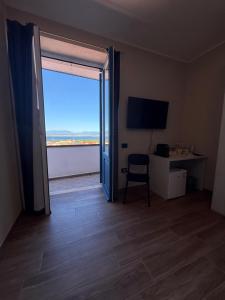 a room with a door open to a desk and a window at La Rosa dei Venti in SantʼAntìoco