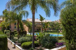 a resort with a swimming pool and palm trees at Floridamar in Jávea