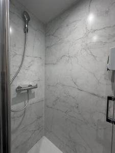 a bathroom with a shower with a marble wall at Fasthotel Laval in Laval