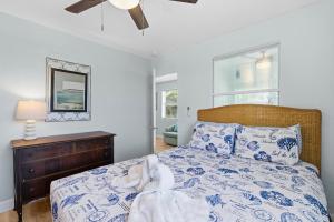 a bedroom with a blue and white bed with a ceiling fan at Flagler Suites 2 in New Smyrna Beach