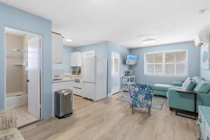 a living room with a couch and a kitchen at Flagler Suites 4 in New Smyrna Beach +35 photos