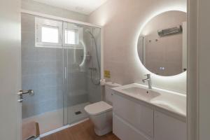 a bathroom with a toilet and a sink and a mirror at Casa Rural Terranova Luxe in Buenache de la Sierra +80 photos