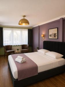 a bedroom with a large bed with two towels on it at Selanikli Hotel Heybeliada in Istanbul