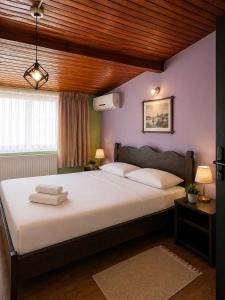 a bedroom with a large white bed with purple walls at Selanikli Hotel Heybeliada in Istanbul