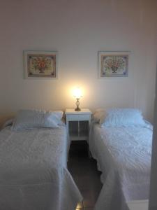 サンタローサにあるLas Acacias De Santa Rosaのベッド2台、テーブル、ランプが備わる客室です。