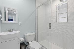 a bathroom with a shower and a toilet and a sink at Flagler Suites 1 in New Smyrna Beach +37 photos