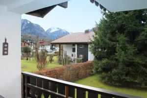 einen Balkon mit Blick auf ein Haus und die Berge in der Unterkunft Oberstdorfer Bergwelt 213 in Oberstdorf