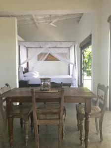 a wooden table with chairs and a bed in a room at Lara's place in Unawatuna