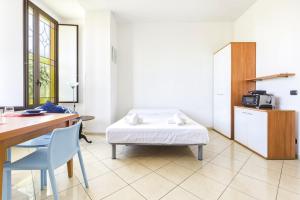 a room with a bed and a desk and a chair at Hostdomus - Villa Emma - Zoe e Ascanio in Alassio