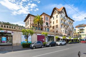 a street with cars parked in front of buildings at Hostdomus - Villa Emma - Zoe e Ascanio in Alassio