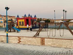 a playground with a play equipment in the sand at casabianca north coast villa code 112 in Dawwār Muḩammad Abū Shanab