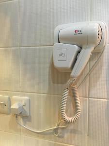 a hairdryer hanging on a wall in a bathroom at Al Meknan Hotel in Al Madinah