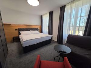a hotel room with a bed and a couch at hostINNec in Dolní Dvořiště