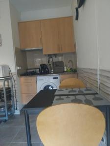 a kitchen with a washing machine and a table at Bienvenue chez Rosa in Vila Real de Santo António