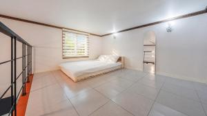 a white room with a bed and a window at Gapyeong Hue 910 Pension in Gapyeong