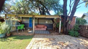 a pergola with a chair and a table in a yard at Kameel Rust and Vrede B & B, Camping and Venue in Stella
