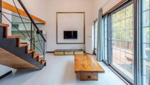 a living room with a wooden bench and a tv at Gapyeong Hue 910 Pension in Gapyeong