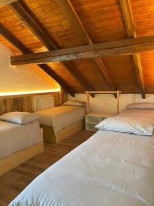 two beds in a room with wooden ceilings at Seandre Holiday Apartments in Prada