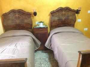 um quarto com 2 camas e uma mesa de cabeceira em B&B Dalle Zie em San Pietro a Maida