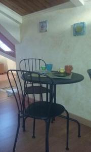 un tavolo nero e una sedia con piatti e tazze sopra di B&B Dalle Zie a San Pietro a Maida