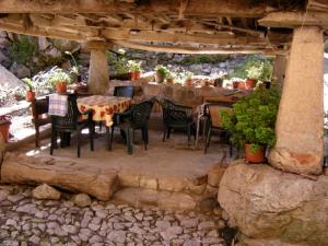 un patio con mesas y sillas bajo una pérgola en El Horrín De Claudia, en Ponga