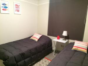 1 dormitorio con 2 camas y mesa con lámpara en Departamento La Serena Laguna del Mar, en La Serena