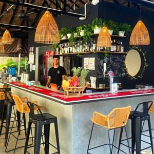 a man standing behind a counter at a bar at THE PLACE Hostel Phnom Penh in Phnom Penh