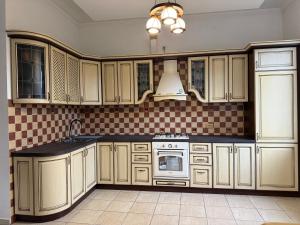 a kitchen with white cabinets and a stove top oven at Solar in Skhidnitsa