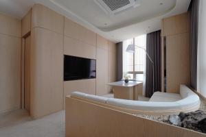 a hotel room with a couch and a tv at UH Suite The Seolleung in Seoul