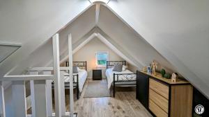a attic room with a bed and a staircase at Le Chalet de la Combe Sainte-Anne in Selongey