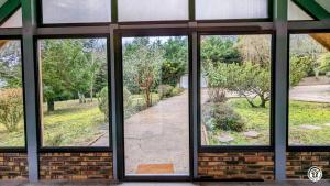 a window in a building looking out at a yard at Le Chalet de la Combe Sainte-Anne in Selongey +20 photos
