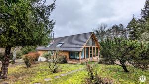 a small house with a metal roof and windows at Le Chalet de la Combe Sainte-Anne in Selongey