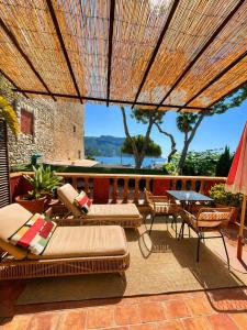 a patio with chairs and a table and an umbrella at Le Jardin d'Emile in Cassis