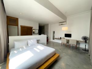a bedroom with a large white bed and a table at Talent Residence in Phnom Penh