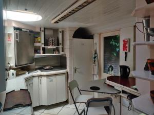 a small kitchen with white cabinets and a table at Frank's Backpackers in Helmond