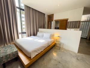 a bedroom with a large bed in a room with windows at Talent Residence in Phnom Penh