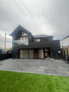 a large black house with a lawn in front of it at 4 Bayswater in New Brighton