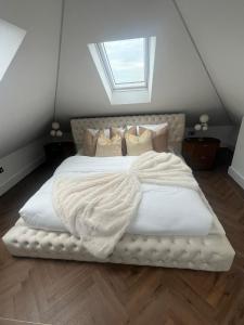 a bedroom with a large white bed with a window at 4 Bayswater in New Brighton