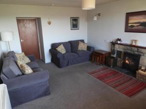 a living room with two couches and a fireplace at Smithy Cottage in Blairgowrie